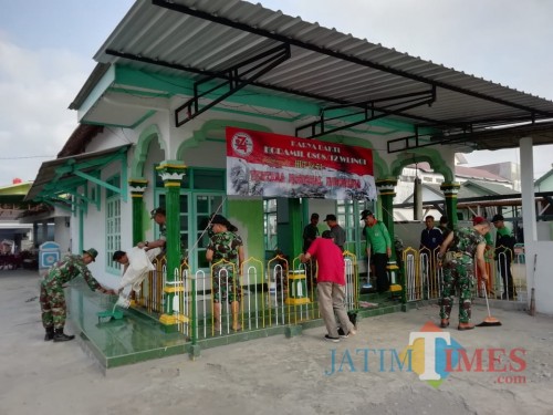 Anggota Koramil Wlingi dan masyarakat gotong royong bersihkan musala.