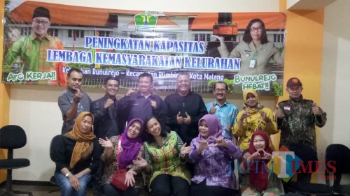 Lurah Bunulrejo, Dra Yuke Siswanti M.Si posisi duduk memakai busana warna hijau (Foto Muklas JatimTIMES)