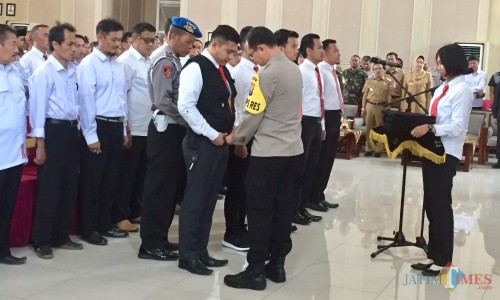 Kapolres Batu, AKBP Harviadhi Agung Prathama saat memasangkan rompi kepada tim satgas Anti Judi dan Money Politic Pilkades Kota Batu di Graha Pancasila, Senin (30/9/2019). (Foto: Irsya Richa/MalangTIMES)