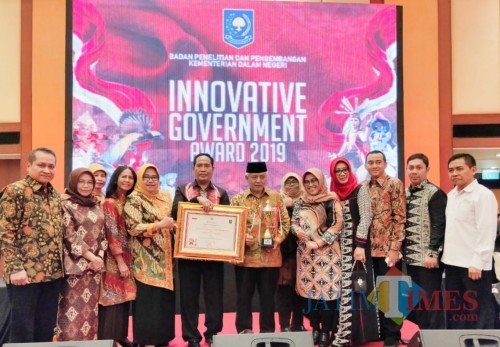 Kepala Balitbangda Kabupaten Malang M Hidayat (pegang piagam) bersama Bupati Malang Sanusi dan pejabat Kabupaten Malang (for MalangTimes)