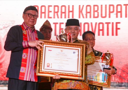 Mendagri Tjahyo Kumolo (kiri) saat memberikan penghargaan Kabupaten Terinovatif kepada Bupati Malang Sanusi. (for MalangTimes)