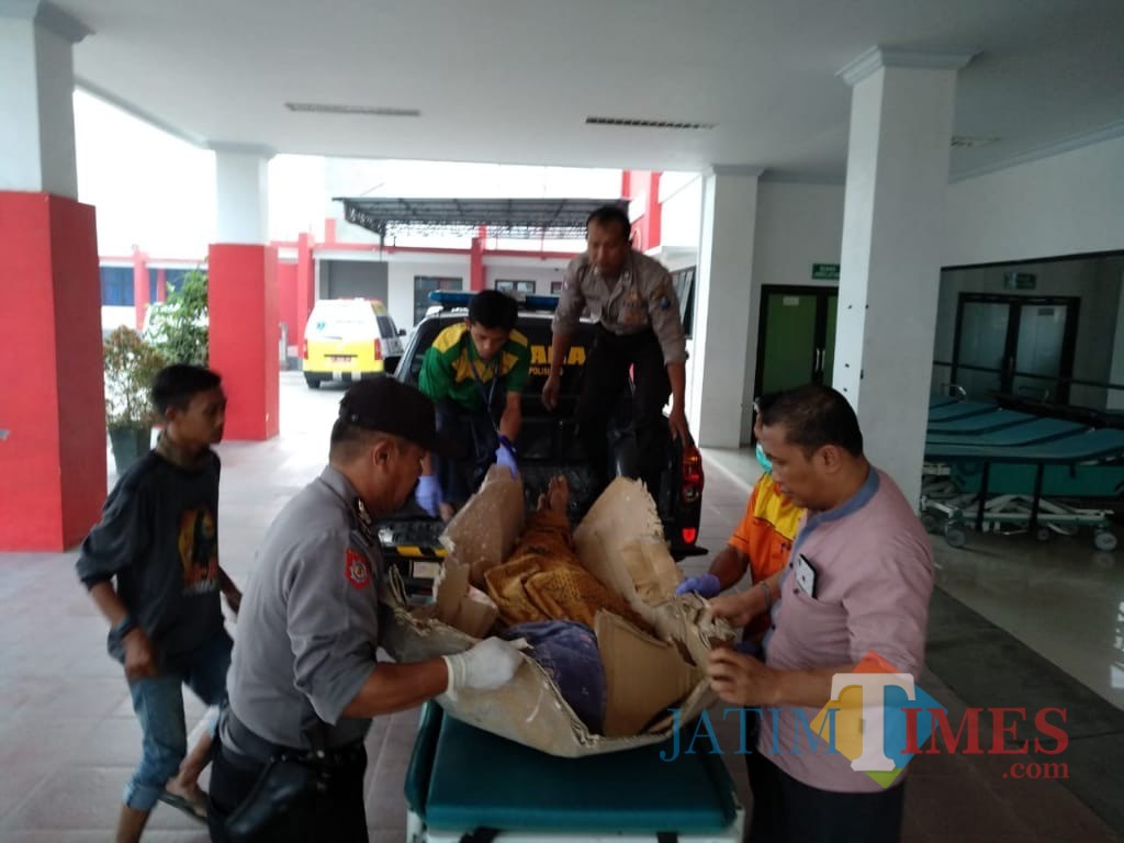 Istri korban saat menagisi jenazah suminya sebelum dievakuasi. (foto: Istimewa / Jatim TIMES)