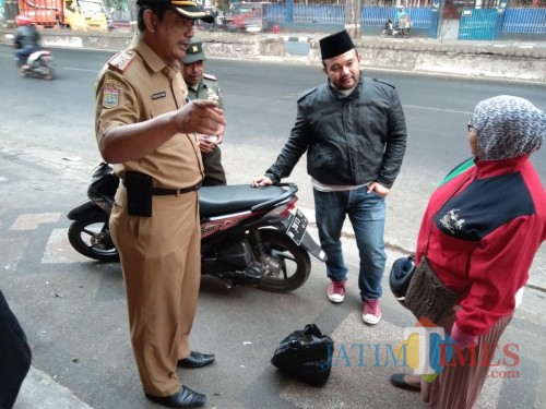 Bagus Sulistyawan Camat Singosari bersama tim saber sampah saat memberikan penjelasan kepada warga yang buang sampah sembarangan (Nana)
