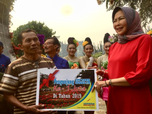 Wali Kota Batu Dewanti Rumpoko saat menyerahkan hadiah kepada pengunjung ke satu juta Iwanudin di Selecta, Minggu (20/10/2019). (Foto: Irsya Richa/MalangTIMES)