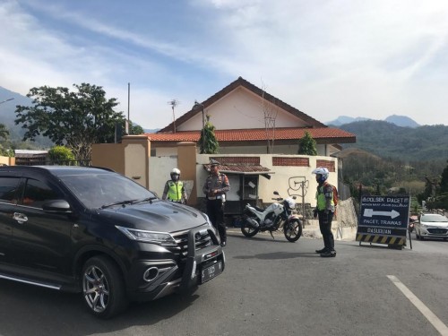 Petugas Polres Mojokerto saat mengondisikan jalur Pacet ke arah Kota Batu di area bundaran taman pacet, (20/10/2019). (Foto: istimewa)