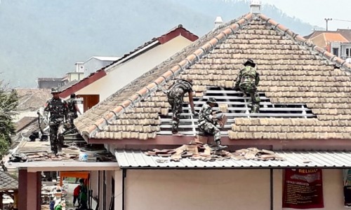 Petugas saat merapikan genting di SDN Tulungrejo 03, Selasa (22/10/2019).