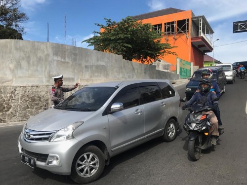 Petugas Polres Mojokerto saat mengondisikan jalur Pacet ke arah Kota Batu di area bundaran taman Pacet, beberapa saat lalu. (Foto: istimewa)