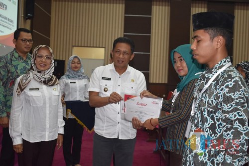 Wabup Marhaeinis menyematkan pin dan menyerahkan sertifikat pelatihan Abang Wira sebagai simbol pengukuhan wirausahawan muda.(Foto : Malik Naharul/BlitarTIMES)