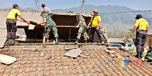 Gotong royong, petugas TNI dan Polisi membetulkan atas rumah warga di Desa Sumber Brantas, Kamis (24/1/02019).