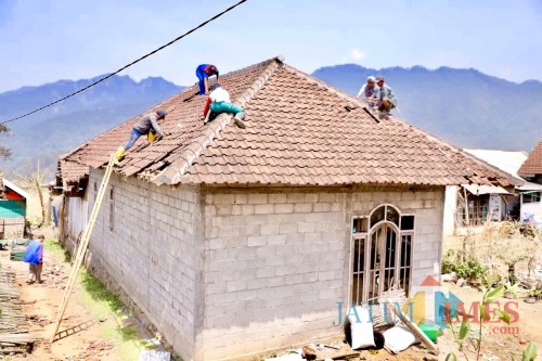 Warga saat membetulkan atap rumah di Desa Sumber Brantas, Kecamatan Bumiaji.