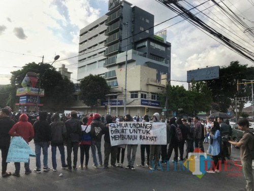 Suasana aksi puluhan massa Aliansi Malang Bergerak di kawasan Simpang Empat Rajabali, Kota Malang, Senin (28/10) (Arifina Cahyanti Firdausi/MalangTIMES)