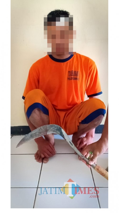 Tersangka Mochamad Roni beserta barang bukti sebilah celurit saat diamankan polisi. (Foto : Humas Polres Malang for MalangTIMES)