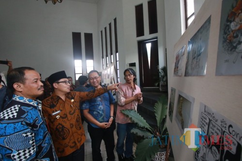 Wali Kota Malang (batik cokelat berkopiah) saat melihat-lihat pameran Saweran Kartun di Balai Kota Malang, Kamis (31/10). (Arifina Cahyanti Firdausi/MalangTIMES)