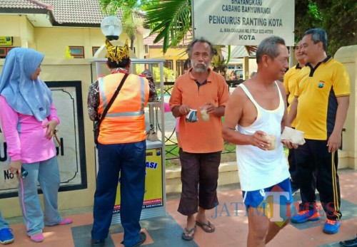 Sejumlah warga tidak mampu mengambil nasi gratis di kios yang ada di depan Polsek Banyuwangi