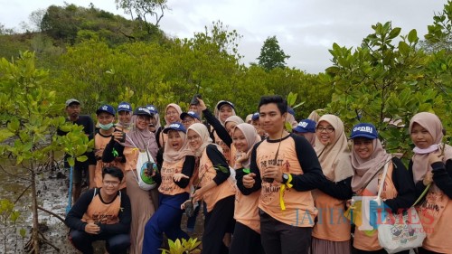 Genbi foto bersama di tengah kegiatan menanam mangrove. (Foto: Imarotul Izzah/MalangTIMES)