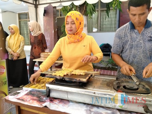 Salah satu peserta bazar saat mengolah ikan. (eko Arif s /JatimTimes)