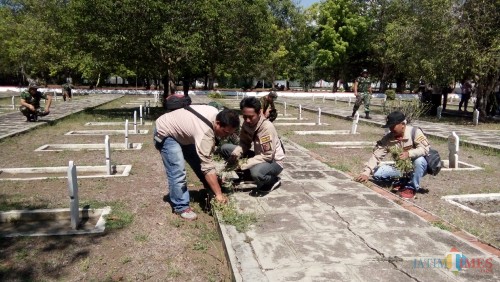 Jurnalis bersama dengan anggota kodim saat membersihkan taman makam pahlawan di Patrang,Jember. (foto : Moh. Ali Makrus / Jatim TIMES)