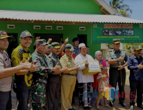 Kepala DPKPCK Kabupaten Malang Wahyu Hidayat (2 dari kiri) berpose di belakang salah satu rumah warga kurang mampu di Kedungsalam (DPKPCK for MalangTimes)