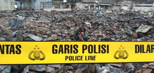Darni mencoba mencari barang berharga yang tersisa. (foto : Joko Pramono/Jatim Tines)