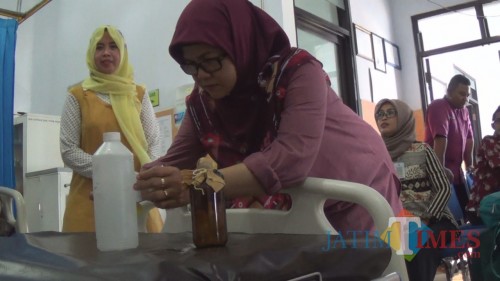 Petugas Dinkes Kabupaten Jombang terlihat memeriksa sampel air untuk masak yang diambil dari TKP. (Istimewa)