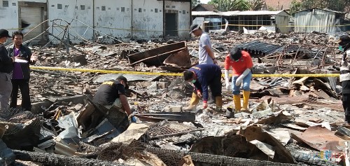 tim Labfor Polda Jatim saat mencari penyebab kebakaran yang meratakan pasar Ngunut (foto : Joko Pramono/Jatim Times)