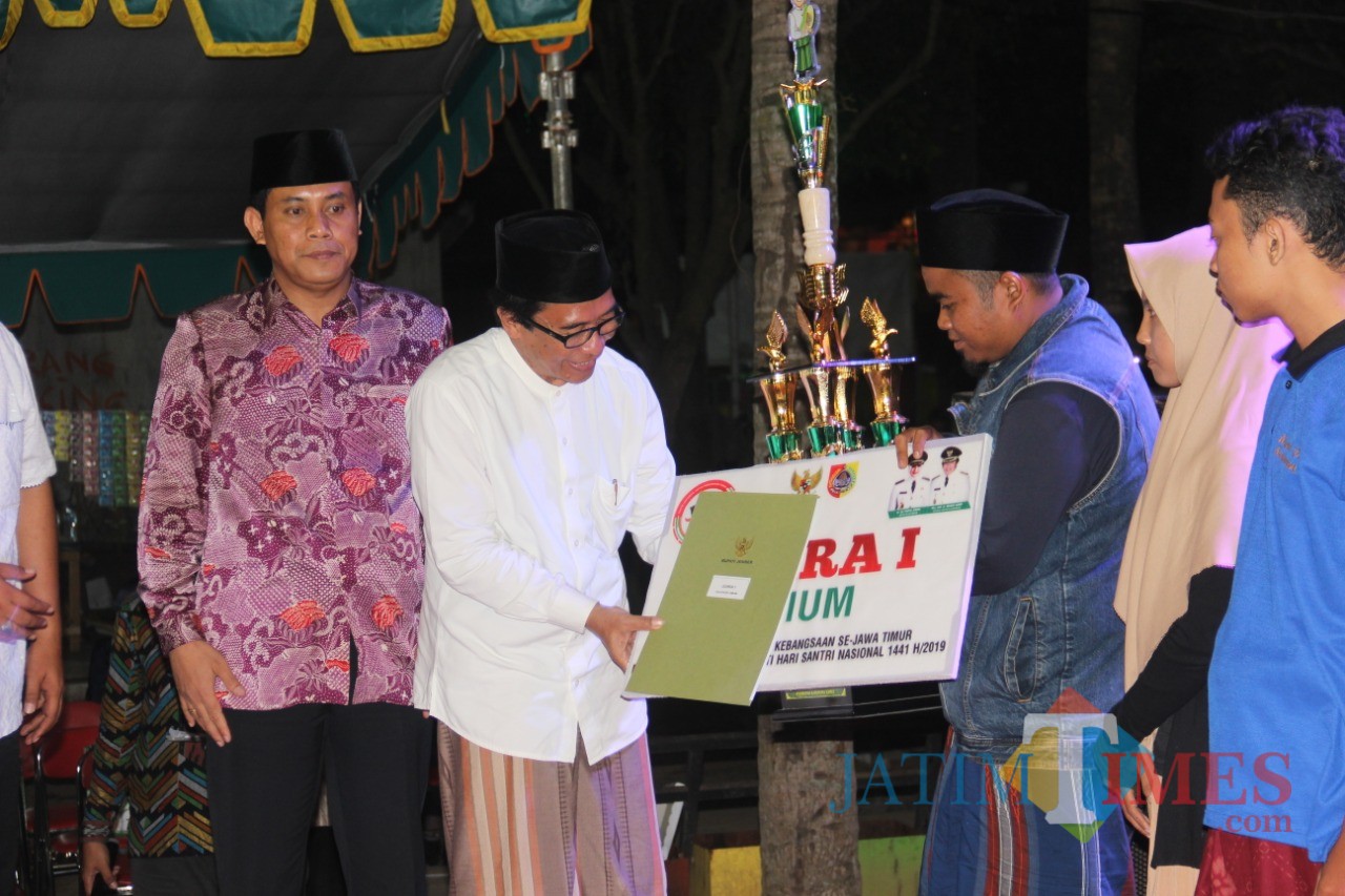 Wakil Bupati Jember Drs. KH. Abdul Muqit Arief saat menyerahkan piagam dan uang pembinaan kepada pemenang lomba (foto : izza / Jatim TIMES)