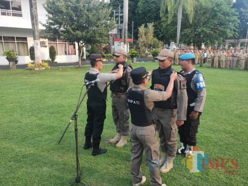 Dua anggota Satpol PP mendapakan atribut Tim Cobra dari Bupati dan Kapolres Lumajang (Foto : Moch. R. Abdul Fatah / Jatim TIMES)