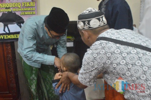 KH. Abdul Muqit Arief saat menyantuni anak yatim pada peringatan Maulid Nabi tadi malam (foto : Ali Makrus / Jatim TIMES)