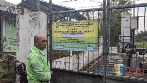 Pemasangan banner oleh petugas BPRD Lumajang (Foto : Moch. R. Abdul Fatah / Jatim TIMES)
