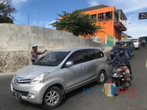 Petugas Polres Mojokerto saat mengondisikan jalur Pacet ke arah Kota Batu di area bundaran taman Pacet, beberapa saat lalu. (Foto: istimewa)
