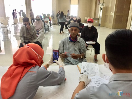 Salah satu warga saat menerima bantuan di Graha Pancasila, Balai Kota Among Tani, Kamis (14/5/2020). (Foto: Irsya Richa/MalangTIMES)