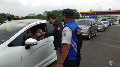Pemeriksaan suhu tubuh di check point exit Madyopuro Tol Mapan saat pelaksanaan PSBB Malang Raya (Pipit Anggraeni/MalangTIMES).