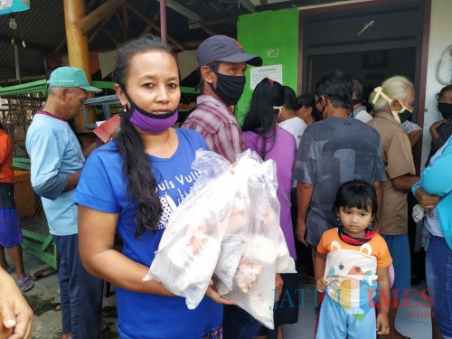 Insiyah menunjukkan tambahan ikan segar yang diterima dalam pencairan BPNT miliknya / Foto : Anang Basso / Tulungagung TIMES