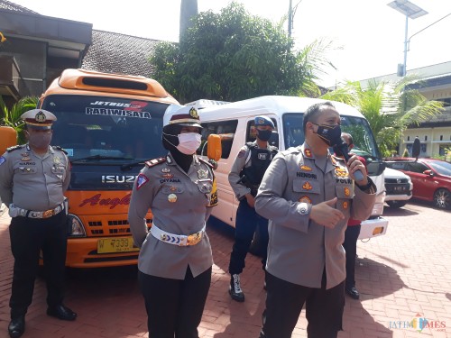 Kapolres Malang AKBP Hendri Umar bersama Kasat Lantas Polres Malang AKP Diyana Suci Listyawati saat rilis kasus travel gelap angkut pemudik di Lapangan Satya Haprabu Mapolres Malang, Jumat (22/5/2020). (Foto: Tubagus Achmad/MalangTimes)