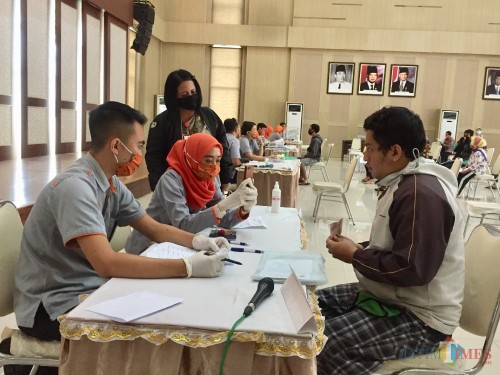 Salah satu warga saat menerima bantuan di Balai Kota Among Tani beberapa saat lalu. (Foto: Irsya Richa/MalangTIMES)
