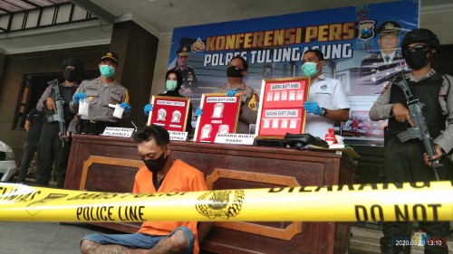 Imam Bahroni tertunduk lesu, nampak Kapolres dan Kasat Reskoba menunjukan bukti sabu dan ekstasi yang disita dari tangan Imam (Foto: Joko Pramono/JatimTIMES)