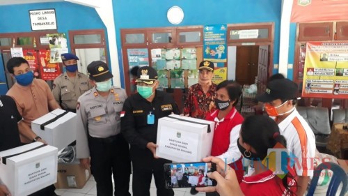 Bupati Malang, HM Sanusi saat membagikan sembako kepada warga terdampak banjir di Pantai Malang Selatan