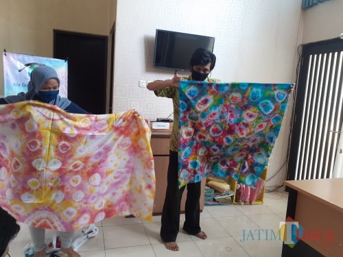 Penginisiasi Batik Netra Adi Gunawan (kanan) saat menunjukkan hasil batik buatan kelompok tunanetra di Kota Malang. (Arifina Cahyanti Firdausi/MalangTIMES).