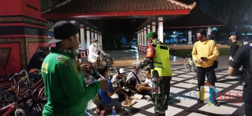 Petugas menertibkan warga yang berkerumun di tempat publik di Kota Blitar.