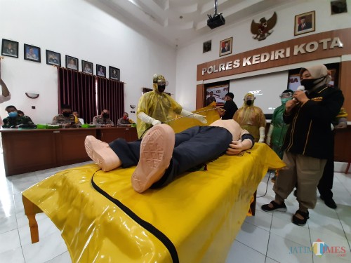 Petugas memberikan tata cara pemulasaraan jenazah covid 18.(eko arif s/Jatimtimes)