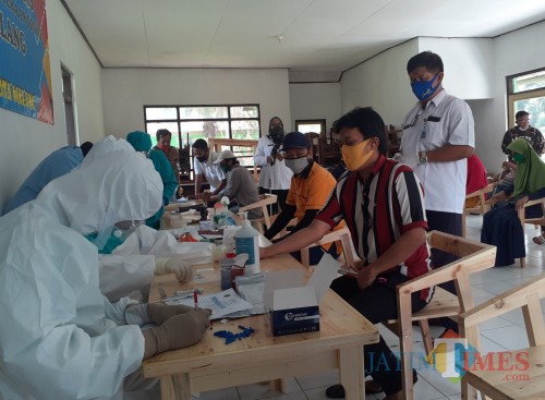 Petugas kesehatan dari Puskesmas Janti saat melakukan rapid test terhadap warga RSBN Malang. (Arifina Cahyanti Firdausi/MalangTIMES).