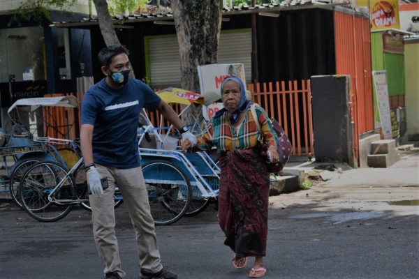 Baskoro, Founder Climate Change Frontier (CCF) saat membantu seorang nenek menyeberang jalan (foto :Istimewa)