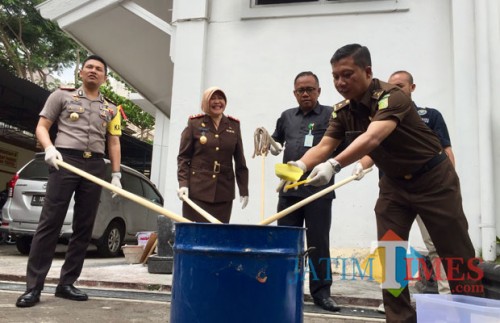 Dari kiri Kapolres Batu AKBP Budi Hermanto, Kajar Kota Batu Nur Chusniah saat memusnahkan barang bukti ganja dan alat bong di halaman Kejari Kota Batu, Senin (29/10/2018). (Foto: Irsya Richa/MalangTIMES)