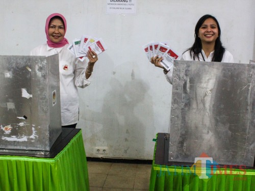 Wali Kota Batu Dewanti Rumpoko (kiri) bersama putrinya Ganis Rumpoko (kanan) menunjukkan surat suara seusai melakukan pencoblosan (Luqmanul Hakim/Malang Times)