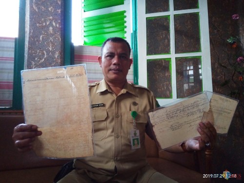 Kepala UPT PPU, Takroni Akbar, saat menunjukkan arsip pendataan buku zaman Belanda di TPU Sukun maupun kwitansi pembayaran pajak makam (Anggara Sudiongko/MalangTIMES)