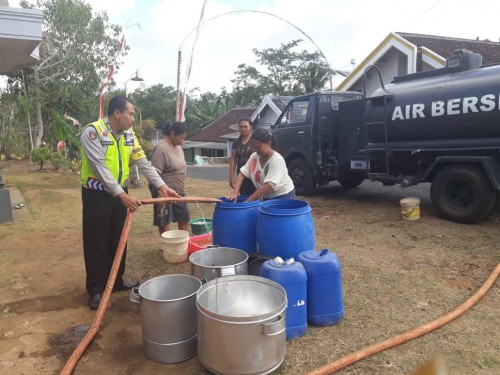 Petugas saat membagikan air bersih kepada warga yang terdampak kekeringan. (Foto : Humas Polres Malang for MalangTIMES)