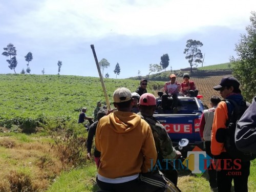 Petani bersama tim TRC BPBD Kota Batu saat menyaksikan detik-detik tim melakukan water bombing di Gunung Arjuna, Sabtu (3/8/3019). (Foto: Irsya Richa/MalangTIMES)
