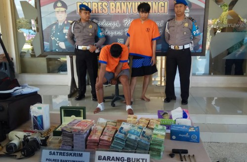 Dua tersangka pembobol rumah kosong dengan barang bukti uang dan perhiasan yang diambil.