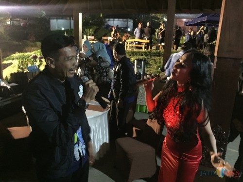 Bebizy bernyanyi bersama kepala DPKPCK, Wahyu Hidayat, di Cafe Sawah, Desa Pujon Kidul, Kecamatan Pujon, Kabupaten Malang, Kamis (8/8/2019). (Foto: Irsya Richa/MalangTIMES)