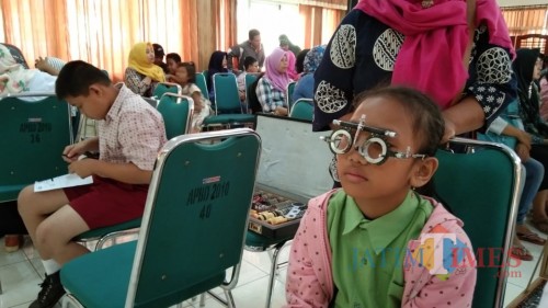 pelajar penerima kacamata greatis saat diperiksa penglihatanya (foto : Joko Pramono/ Jatim Times)